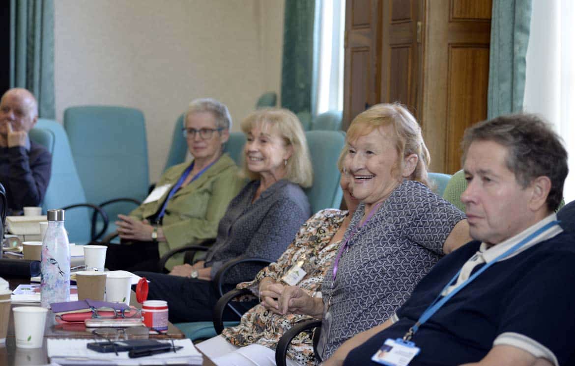 Group sat in training with smiling woman
