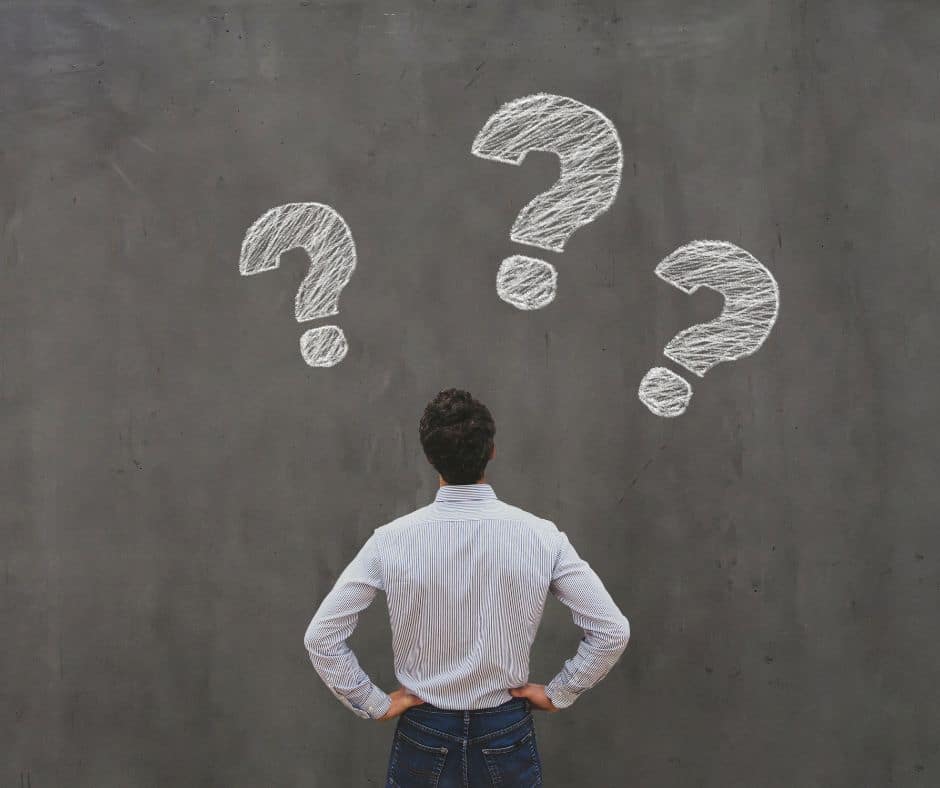 Man facing a wall covered in question marks
