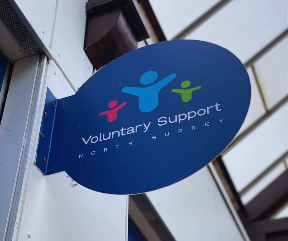 Photograph of oval shop sign with Voluntary Support North Surrey name and logo on