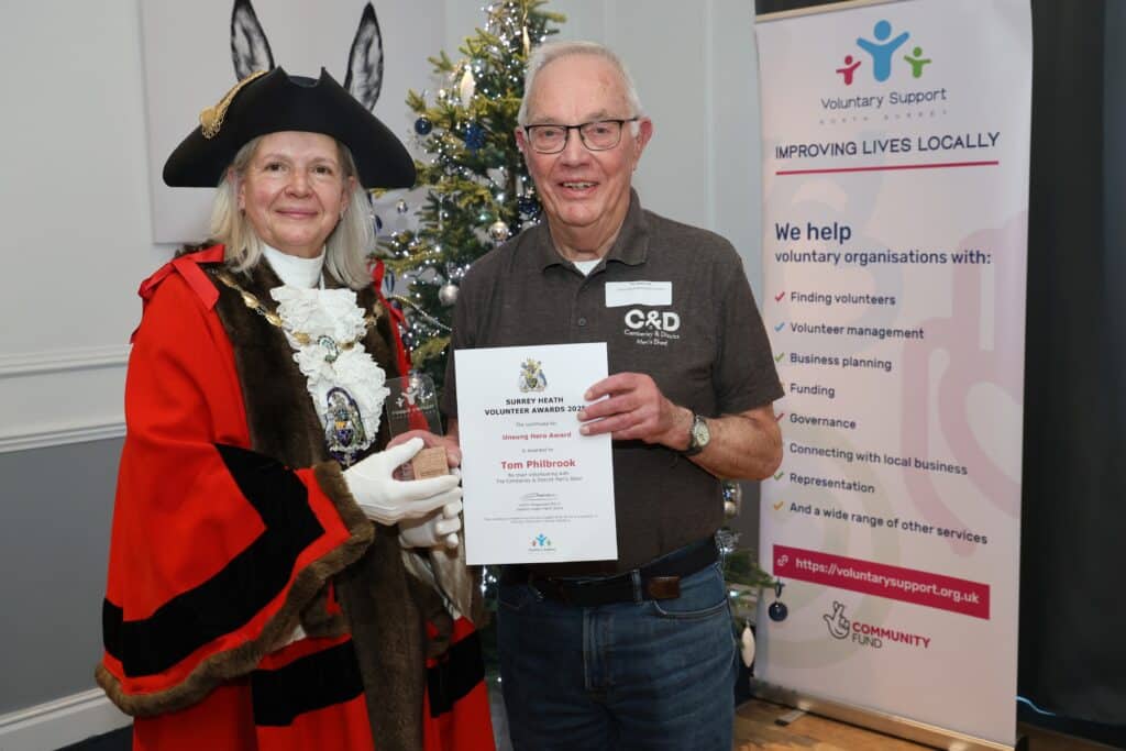Surrey Heath mayor in red and black robe and black tricorn with smiling man with white hair and glasses