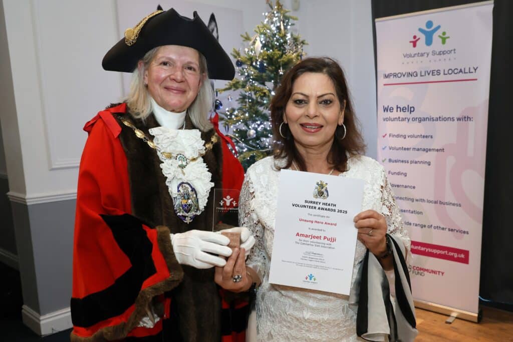Surrey Heath mayor in red and black robe and black tricorn with smiling woman
