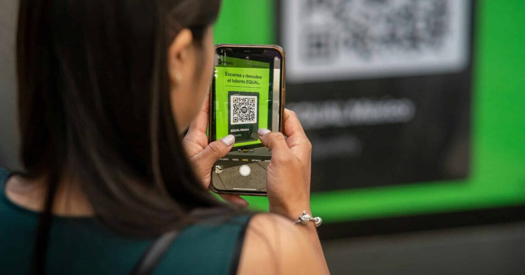 Woman holding up her phone to capture QR code