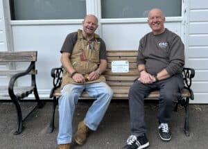 Two volunteers from Men in Sheds sat on chatty bench at Camberley bowling green