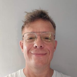 Headshot of smiling man with short blonde hair