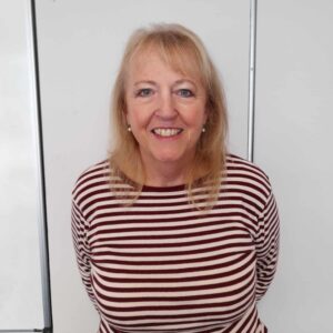 Head and shoulders shot of smiling woman with shoulder length blonde hair and fringe